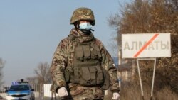 Военнослужащий в маске и бронежилете на блокпосту у границы Алматы. 30 марта 2020 года.